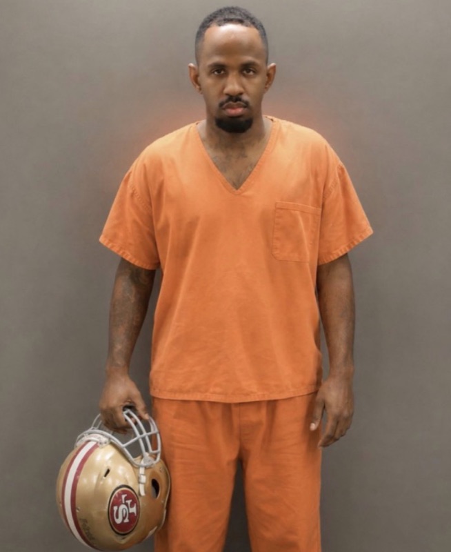 Fan edit of the Ada County booking photo with a 49ers helmet added under his arm